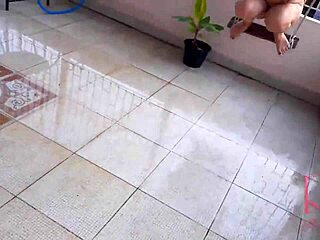 En hemmafru hänger sig åt att svänga utan underkläder medan hon söker skydd från regn under ett paraply i en klassisk helkroppsvideo