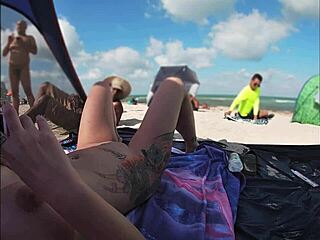 Strand-Voyeurismus mit einer nackten Frau und mehreren Männern, die zusehen